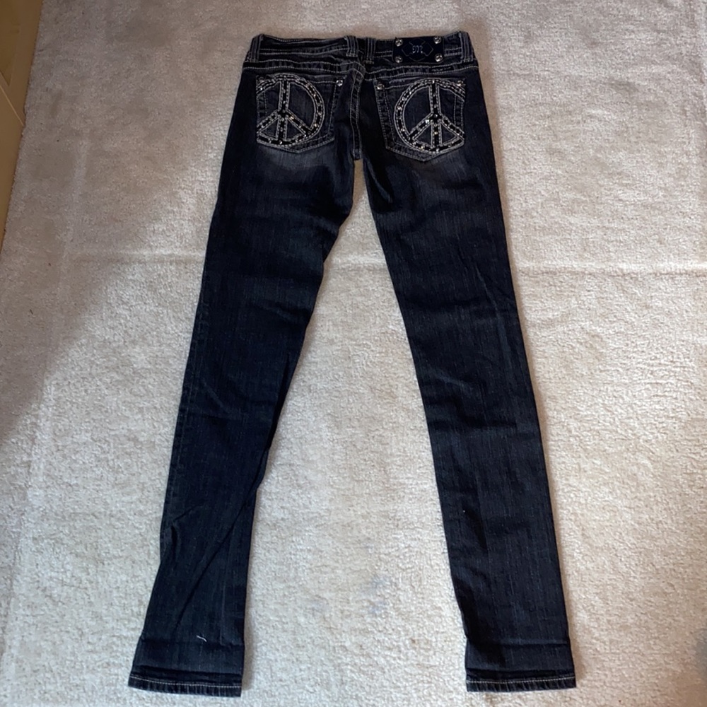 Miss Me black skinny jeans, peace sign bedazzled pockets, gray border stitch.